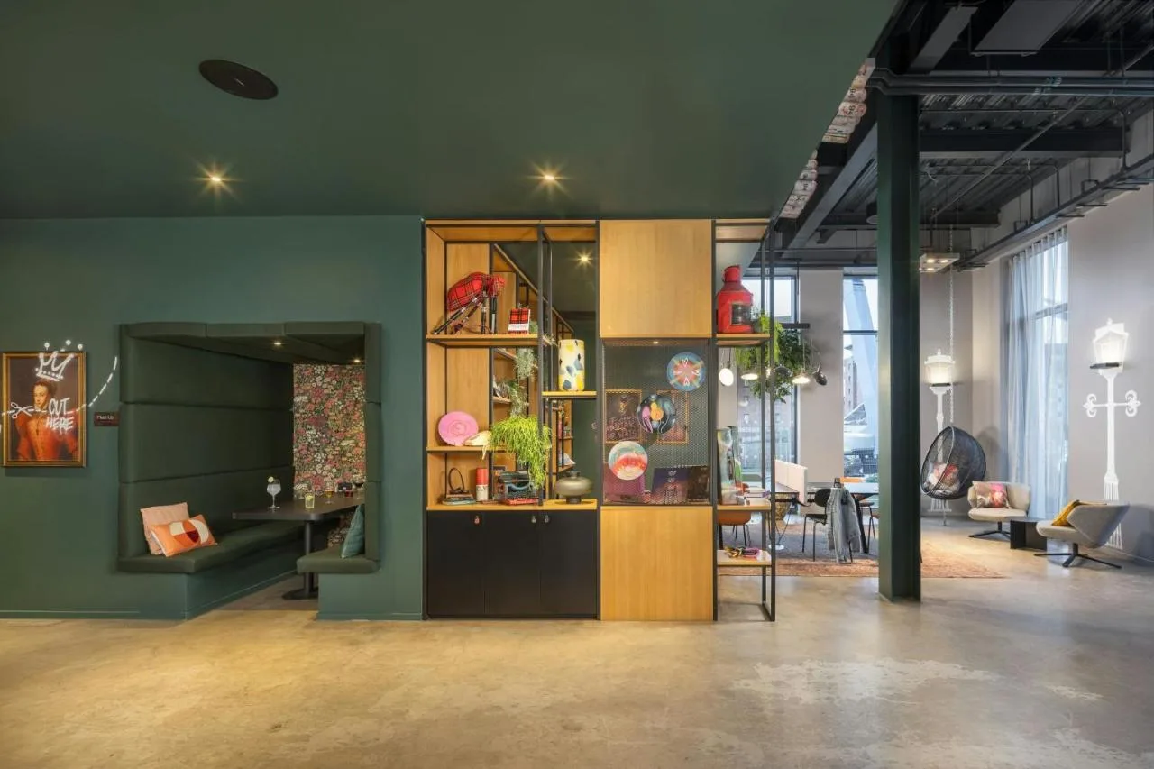 a room with green walls and a table and chairs at Moxy Glasgow Merchant City in Glasgow
