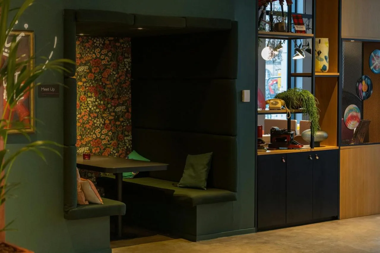 a room with a bench and a table in it at Moxy Glasgow Merchant City in Glasgow