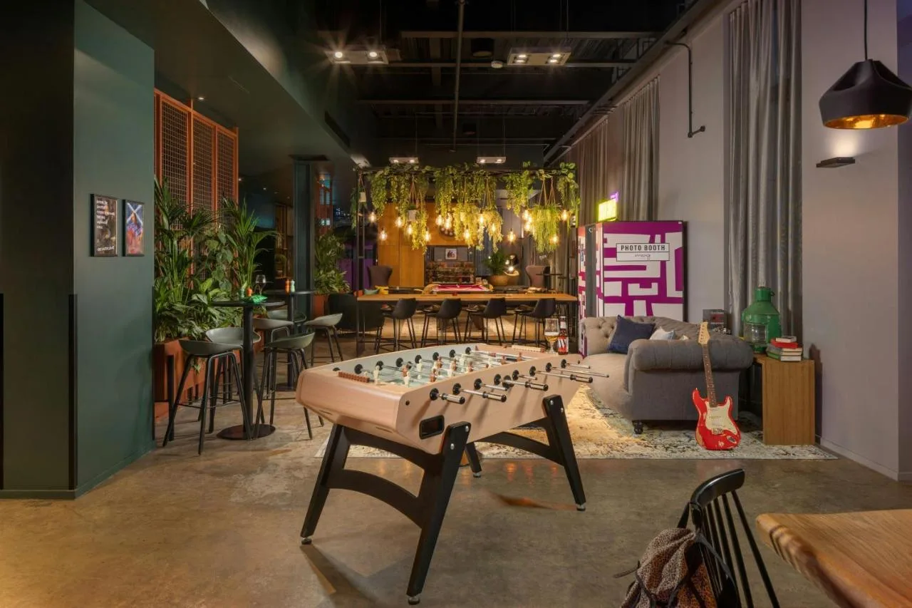 a living room with a large chess board on a table at Moxy Glasgow Merchant City in Glasgow